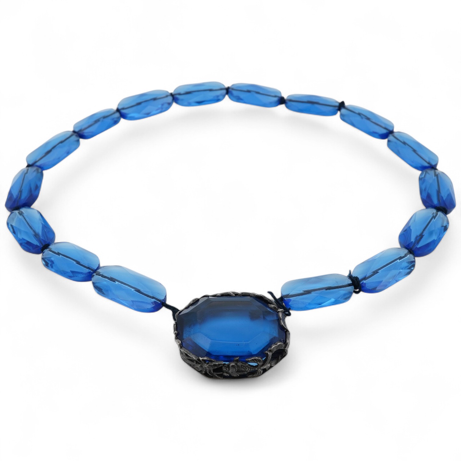 A silver and paste necklace, composed of faceted blue paste beads, the clasp set with a blue paste, in a silver mount decorated with sea creatures, length 40cm, Chinese mark for silver, maker's mark CHC